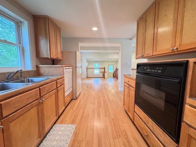 222 Dogwood Ave NW, Menahga, MN 56464 - kitchen with black oven, light wood-type flooring, dishwasher, recessed lighting, and brown cabinets