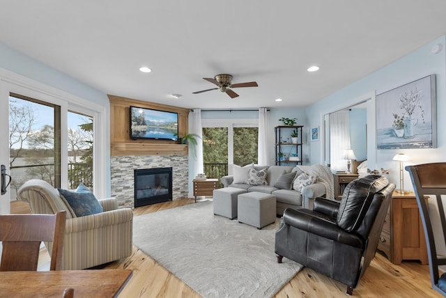 living room with recessed lighting, light wood-style flooring, ceiling fan, and a fireplace