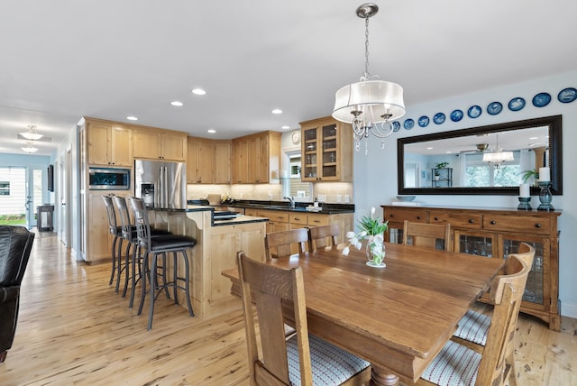 dining space featuring light wood-style floors, baseboards, recessed lighting, and a chandelier