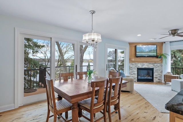 dining area featuring a healthy amount of sunlight, a fireplace, and light wood finished floors