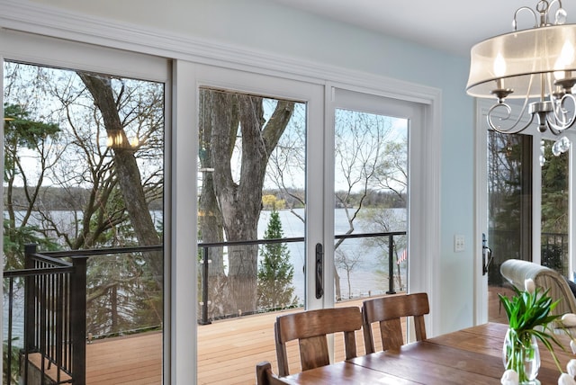 dining space featuring a water view and a notable chandelier