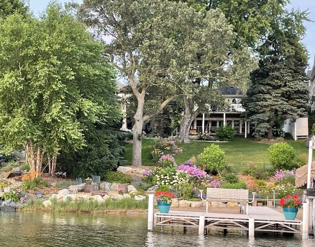 view of dock with a water view and a yard