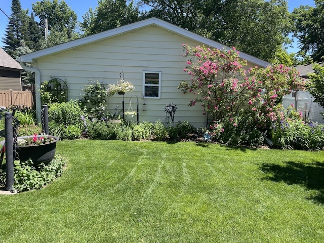 view of side of property with a lawn and fence