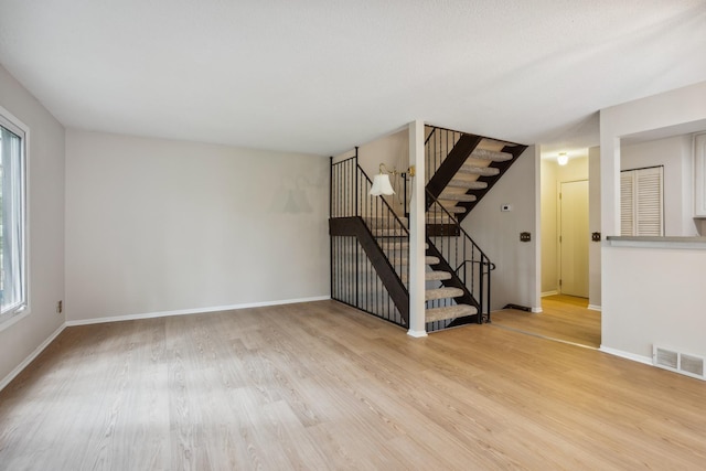 4854 Grenwich Trl N, Oakdale, MN 55128 - unfurnished living room featuring light wood-type flooring and stairs