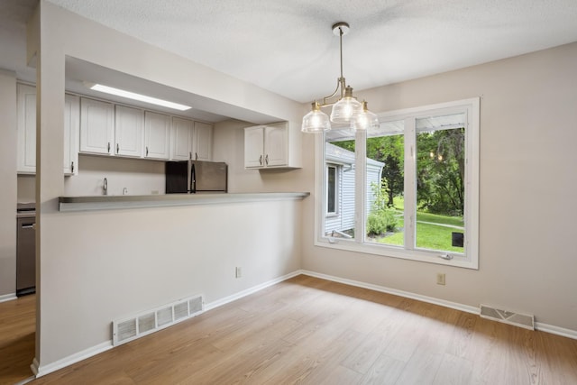 4854 Grenwich Trl N, Oakdale, MN 55128 - kitchen with freestanding refrigerator, light wood-style floors, decorative light fixtures, light countertops, and white cabinetry