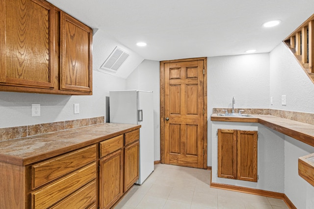 6524 Minnetonka Blvd, Saint Louis Park, MN 55426 - kitchen with a sink, white fridge with ice dispenser, brown cabinets, recessed lighting, and lofted ceiling