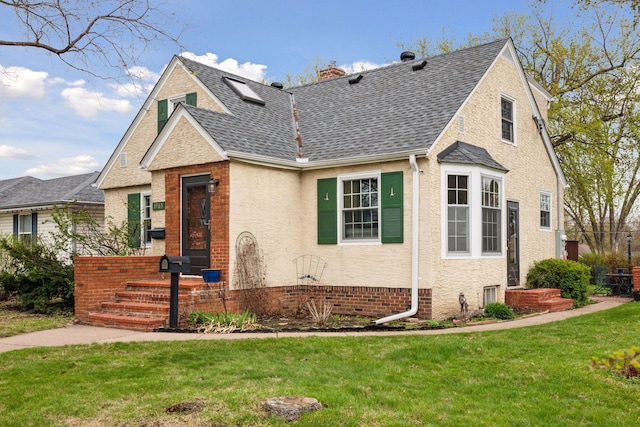 view of front facade with a shingled roof, a front lawn, and a chimney