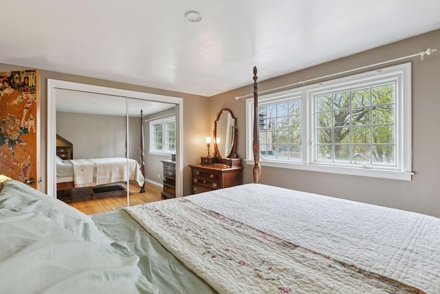 bedroom with baseboards, a closet, and wood finished floors