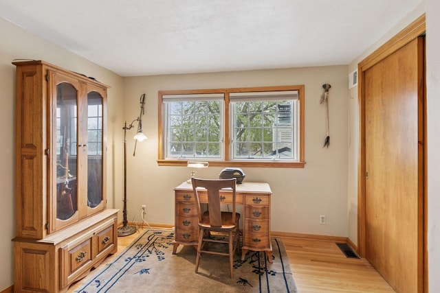 office space with visible vents, baseboards, a healthy amount of sunlight, and light wood-style floors