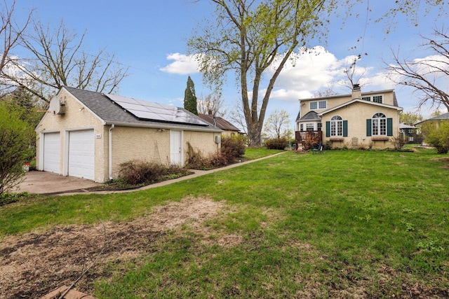 view of home's exterior featuring a yard, a chimney, and solar panels