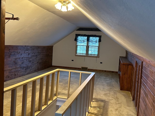 bonus room with visible vents, a textured ceiling, carpet, and vaulted ceiling