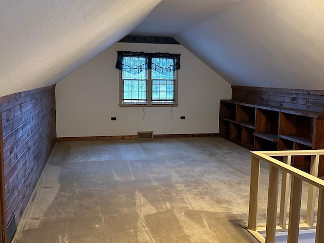 additional living space featuring carpet floors and vaulted ceiling