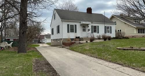 1213 Minnesota Ave, Detroit Lakes, MN 56501 - view of front of home with a chimney, a front lawn, and concrete driveway