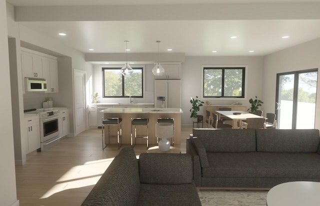 living room with a wealth of natural light, light wood-style flooring, and recessed lighting