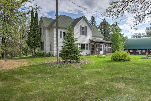 35449 Hastings St NE, Cambridge, MN 55008 - rear view of property with a sunroom, a yard, and a shingled roof