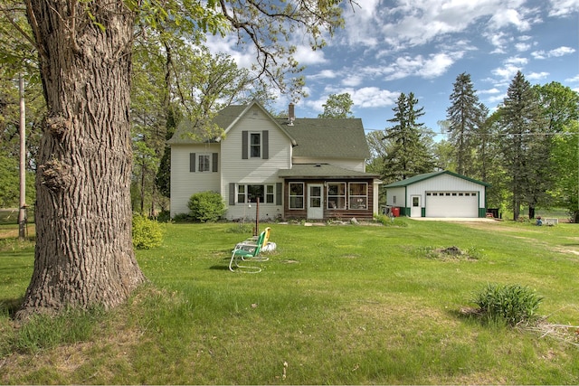 35449 Hastings St NE, Cambridge, MN 55008 - rear view of house featuring a sunroom, an outbuilding, a garage, a shingled roof, and a yard