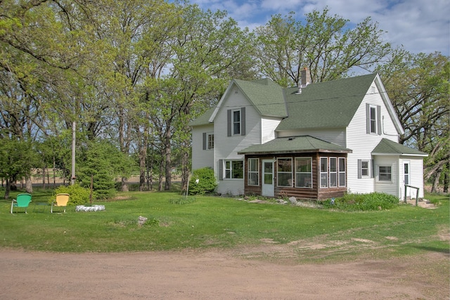 35449 Hastings St NE, Cambridge, MN 55008 - back of house featuring roof with shingles, a sunroom, a chimney, and a yard