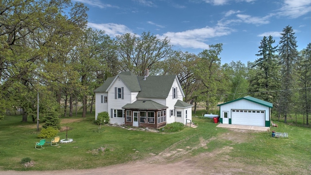 35449 Hastings St NE, Cambridge, MN 55008 - view of front facade featuring a sunroom, an outbuilding, a garage, a shingled roof, and a front lawn