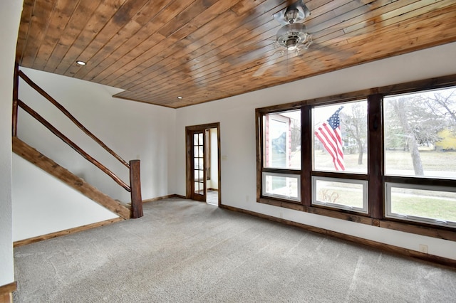 unfurnished living room featuring baseboards, wooden ceiling, carpet flooring, and plenty of natural light