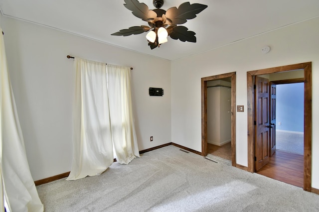 unfurnished bedroom featuring visible vents, baseboards, a ceiling fan, and light colored carpet