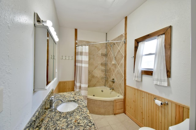 bathroom with vanity, tiled shower / bath, a wainscoted wall, wood walls, and tile patterned floors