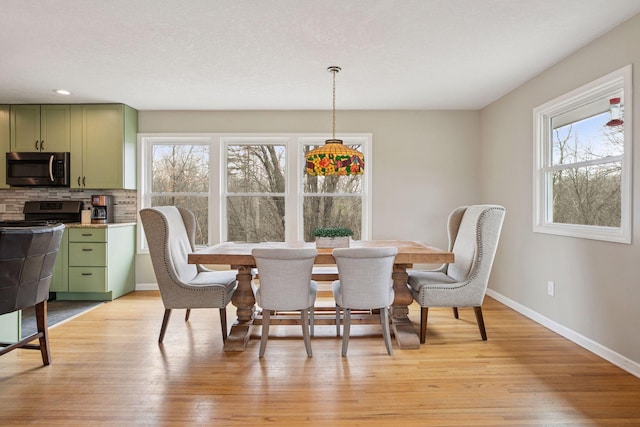dining room with recessed lighting, plenty of natural light, light wood-style flooring, and baseboards
