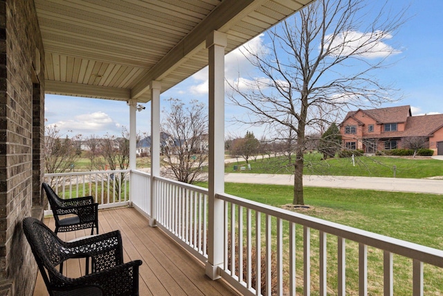 wooden deck featuring a porch and a yard