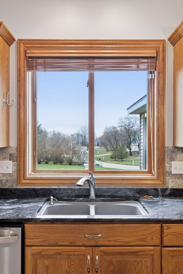 kitchen featuring a wealth of natural light, dishwasher, a sink, and tasteful backsplash