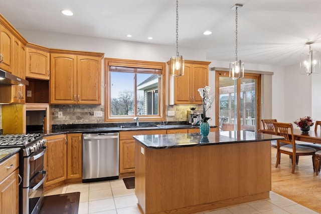 kitchen featuring a center island, a sink, appliances with stainless steel finishes, and a healthy amount of sunlight
