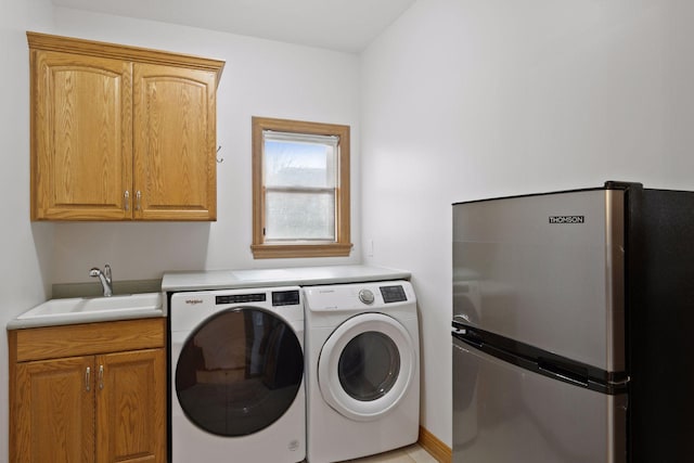 washroom featuring independent washer and dryer, laundry area, and a sink