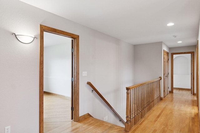 corridor featuring baseboards, recessed lighting, an upstairs landing, and light wood-type flooring