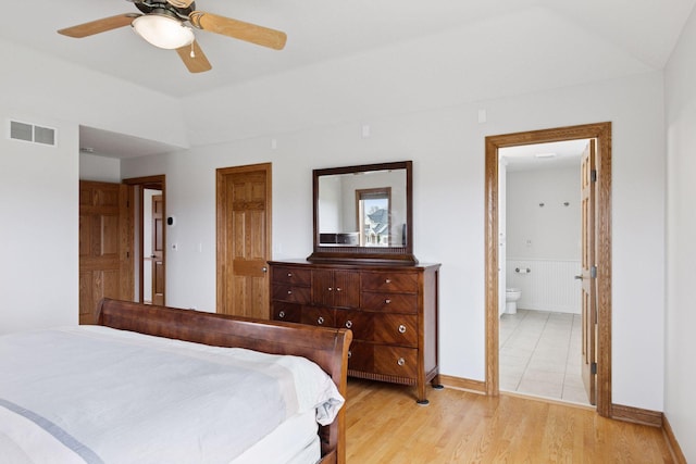 bedroom with connected bathroom, baseboards, visible vents, and light wood-type flooring