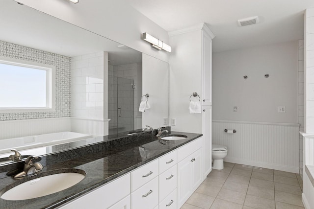 bathroom with double vanity, tile patterned flooring, a stall shower, and a sink