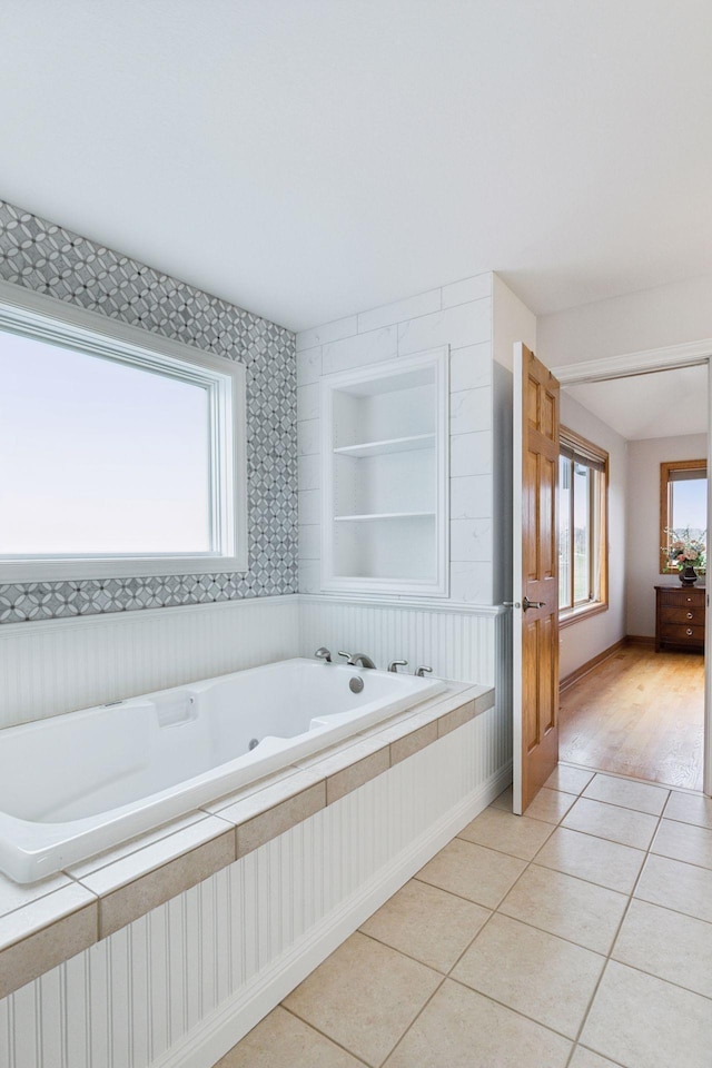 bathroom featuring a garden tub, tile patterned flooring, and baseboards