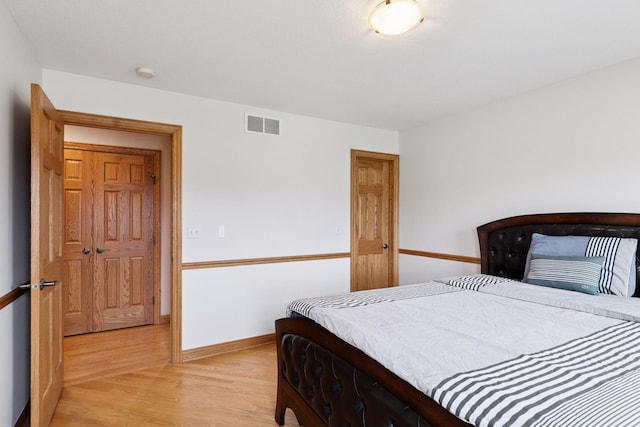 bedroom featuring baseboards, visible vents, and light wood-style flooring