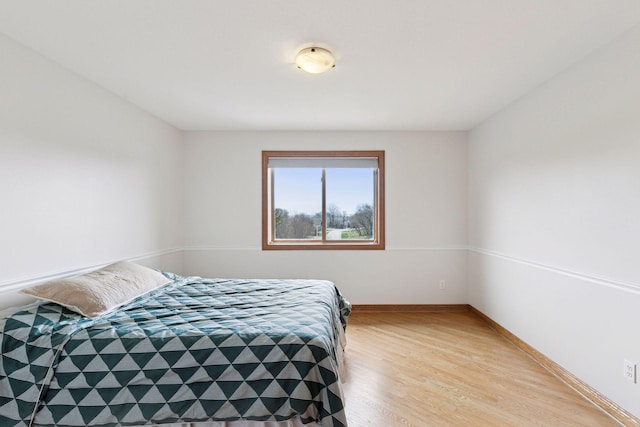 bedroom featuring light wood finished floors and baseboards