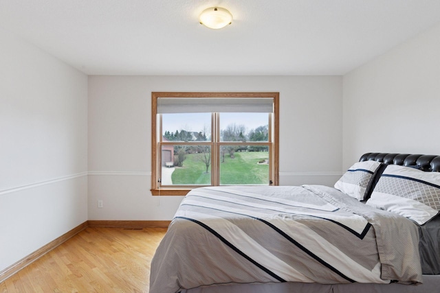 bedroom with baseboards and light wood-type flooring