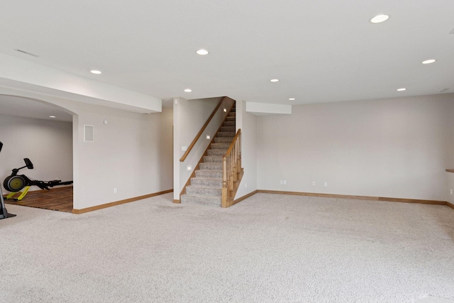 finished basement with light colored carpet, baseboards, recessed lighting, and stairway