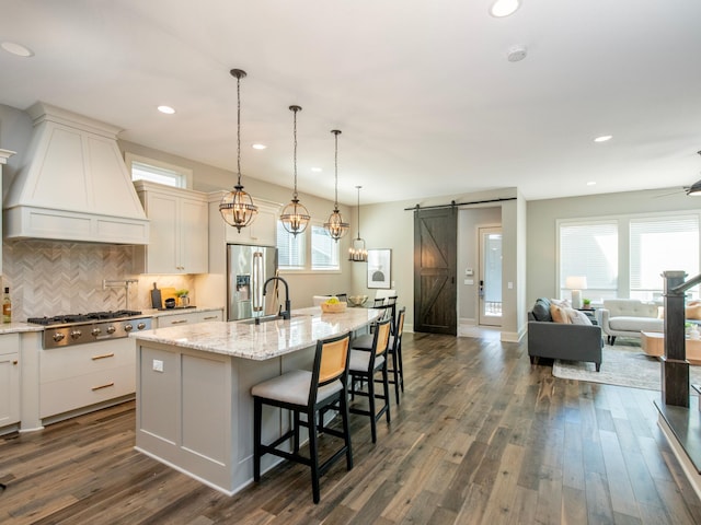 2728 Chowen Ave S, Minneapolis, MN 55416 - kitchen featuring decorative backsplash, dark wood-style floors, premium range hood, a barn door, and stainless steel appliances