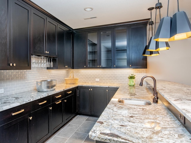 2728 Chowen Ave S, Minneapolis, MN 55416 - kitchen with a sink, backsplash, light stone countertops, and glass insert cabinets