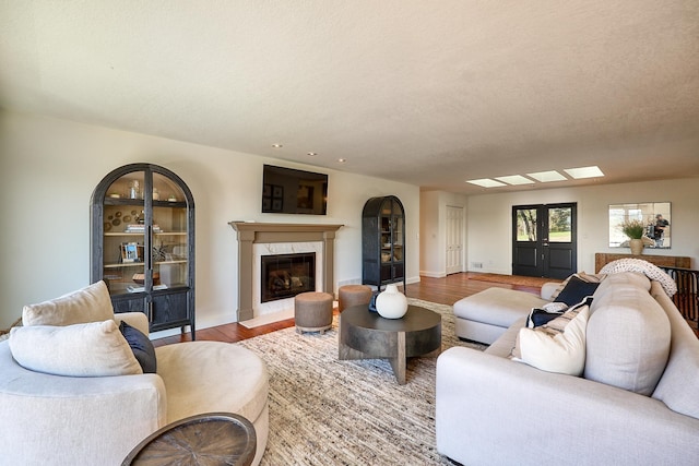 living area with baseboards, wood finished floors, and a premium fireplace