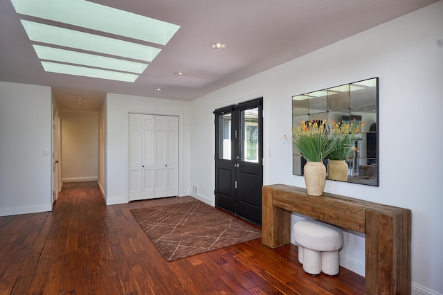 entrance foyer featuring baseboards, a skylight, and hardwood / wood-style flooring