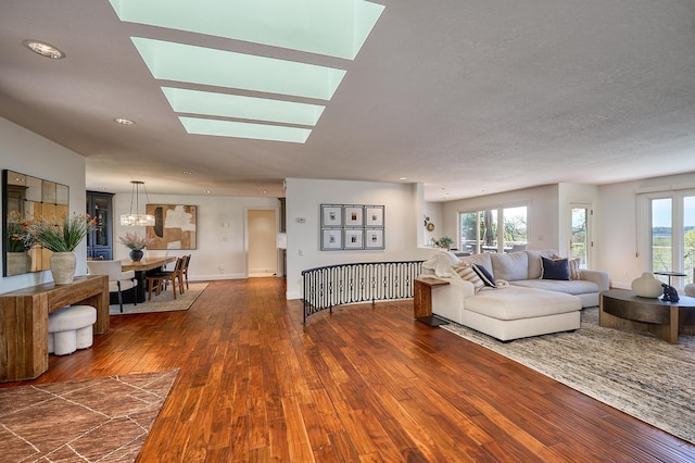 living room with recessed lighting, baseboards, a skylight, and dark wood-style floors