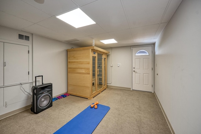 workout room featuring visible vents, baseboards, a drop ceiling, and light colored carpet
