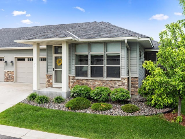 1128 Willowbrook Cir, Delano, MN 55328 - view of front of home featuring an attached garage, concrete driveway, stone siding, and a shingled roof