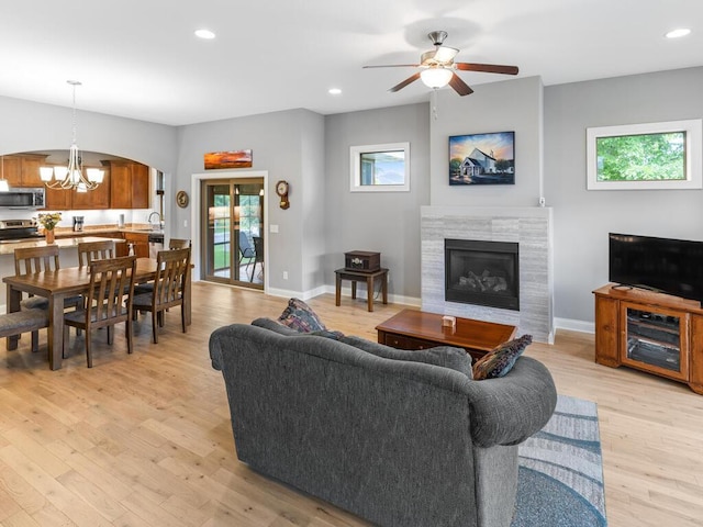 1128 Willowbrook Cir, Delano, MN 55328 - living room featuring a chandelier, light wood-type flooring, a fireplace, recessed lighting, and arched walkways
