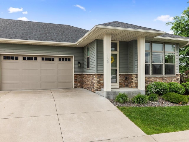 1128 Willowbrook Cir, Delano, MN 55328 - view of front of property with a garage, stone siding, driveway, and roof with shingles