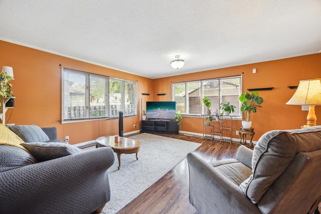 living room featuring dark wood finished floors, baseboards, a textured ceiling, and crown molding