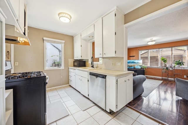 kitchen with stainless steel dishwasher, gas range, under cabinet range hood, and plenty of natural light