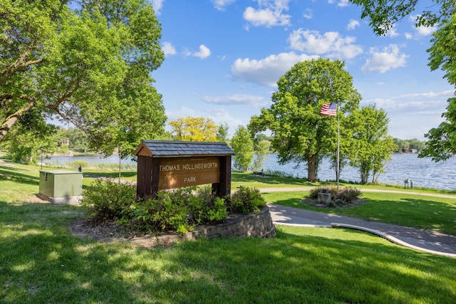view of home's community with a water view and a lawn